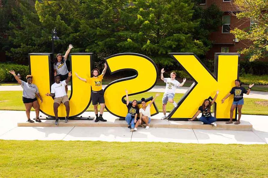 Group of 优德app students taking a picture by the 优德app sign.