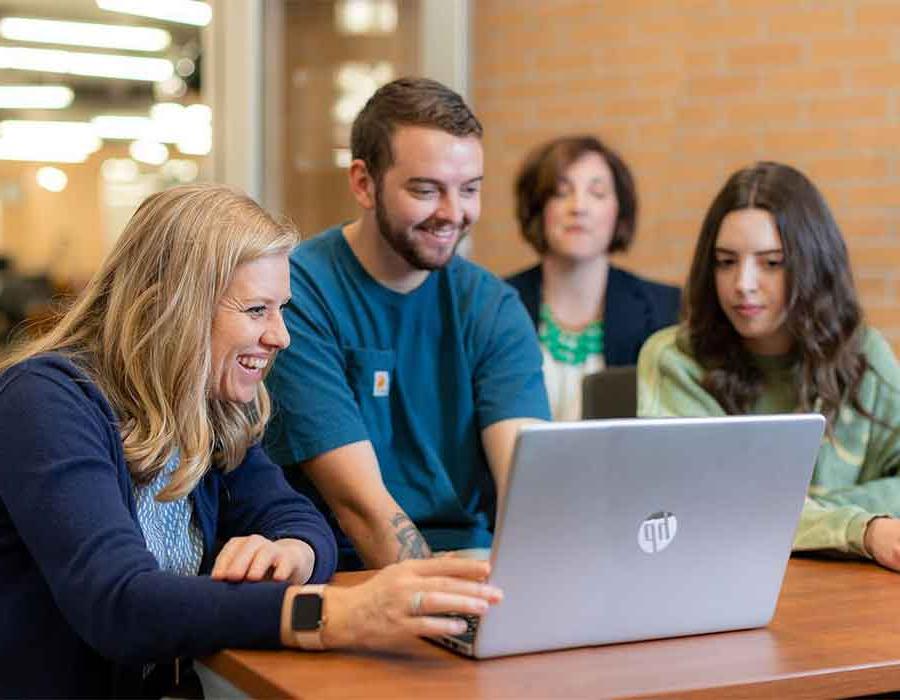 group of ksu students looking at a laptop.